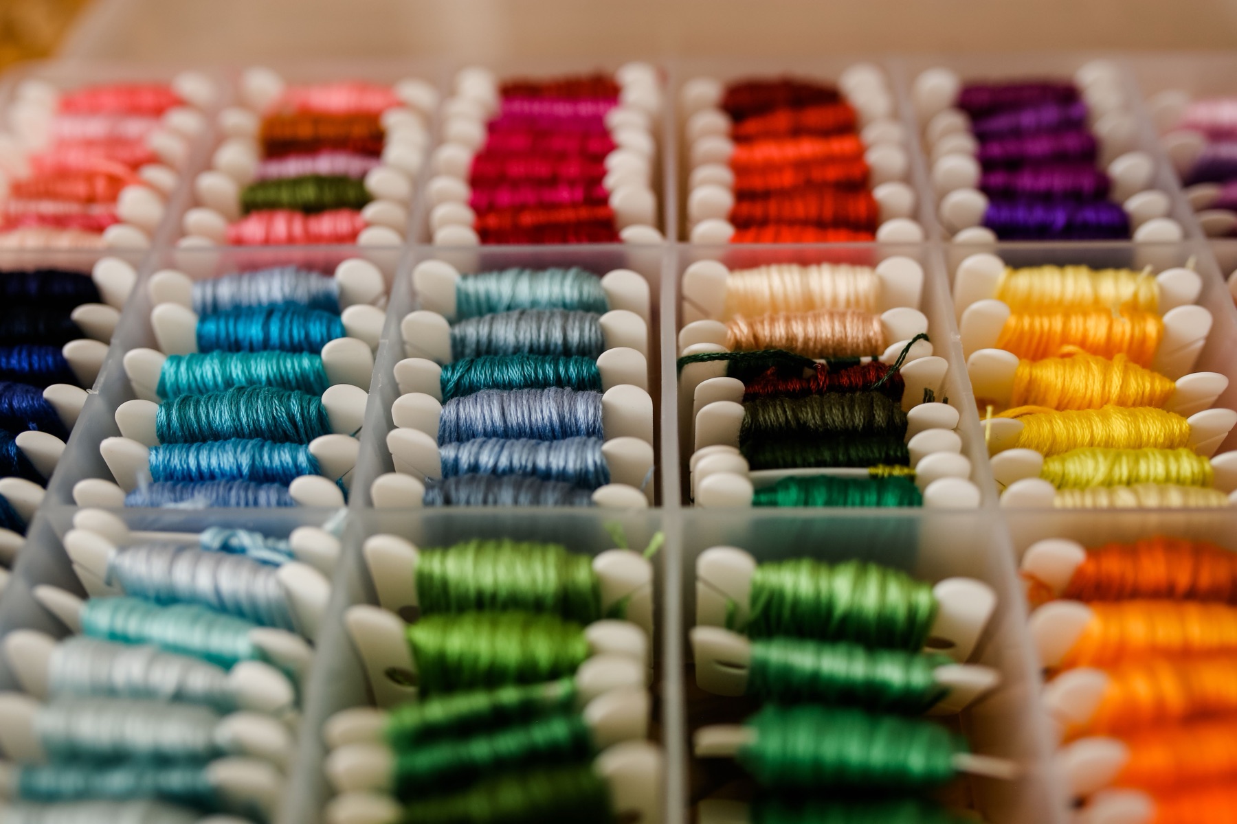 Fils de broderie de couleurs variées rangés dans un atelier textile