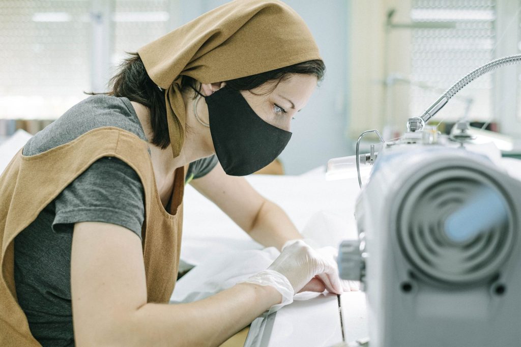 Opératrice textile en équipement de protection (masque, gants)