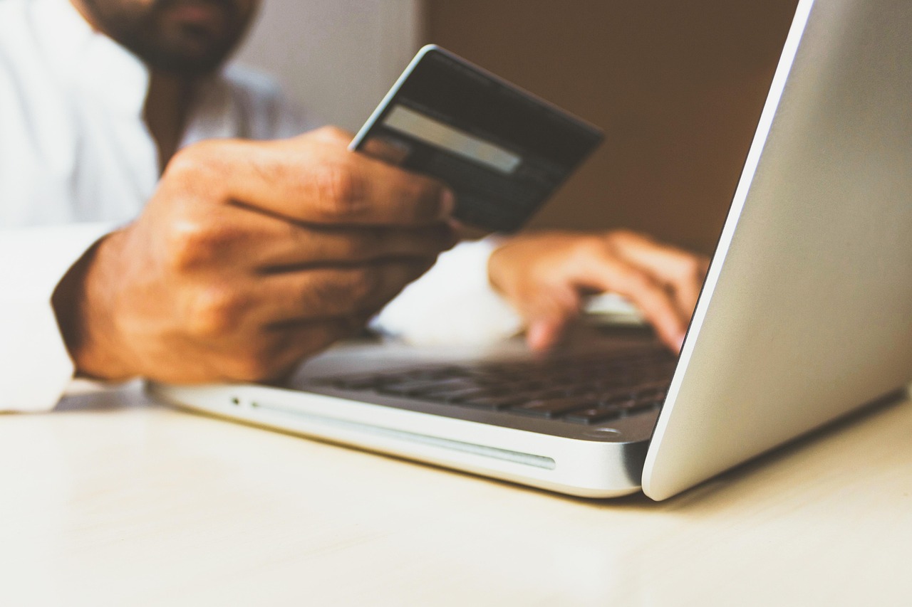 paiement en ligne par carte bancaire sur un ordinateur portable, gros plan sur les mains et la carte
