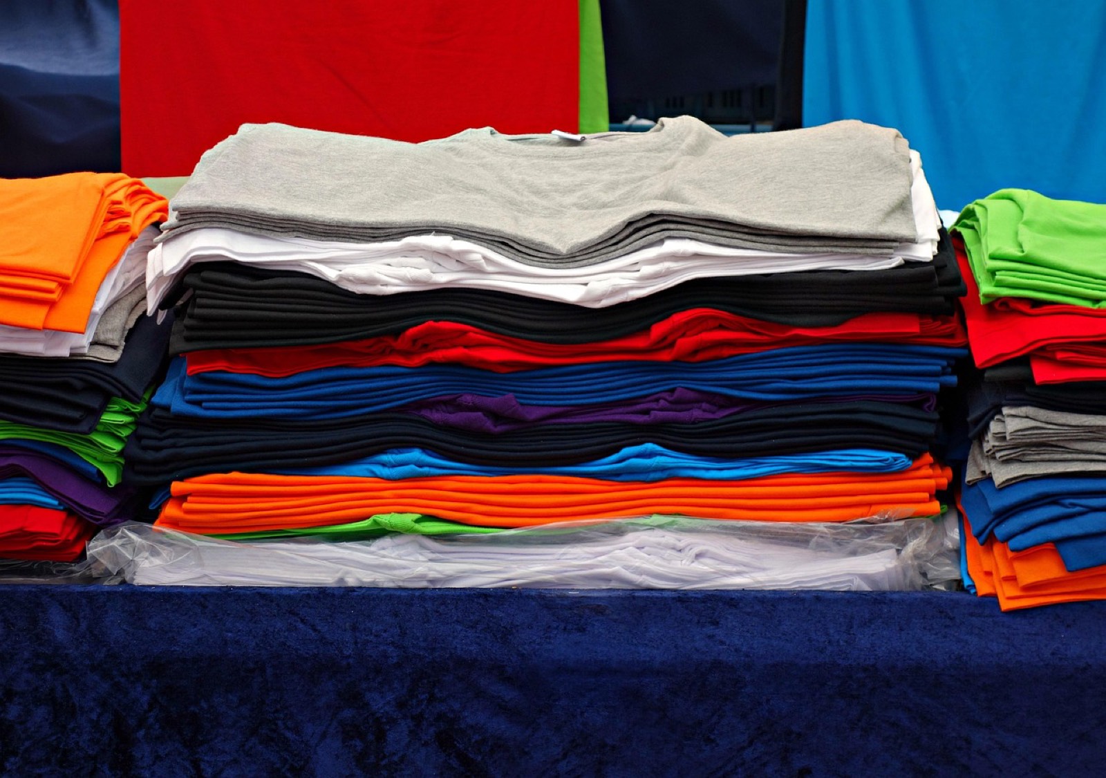 Tee-shirts de travail pliés en pile sur une table claire