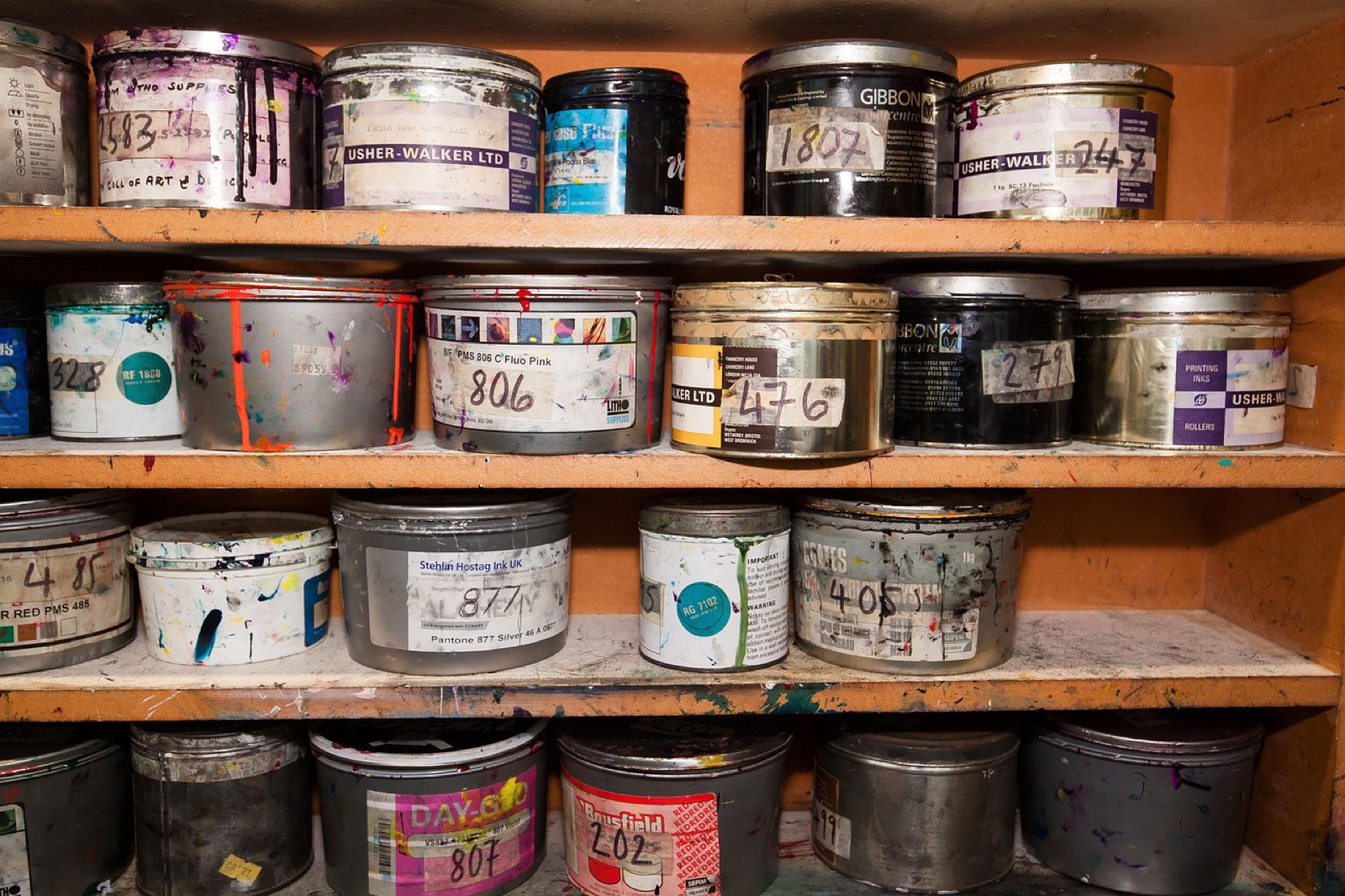 Bureau d'un atelier de sérigraphie avec des factures posées à côté de l'ordinateur