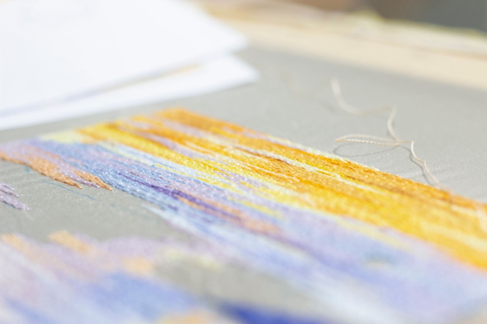 Échantillon de broderie en gros plan sur tissu, fils de couleur visibles