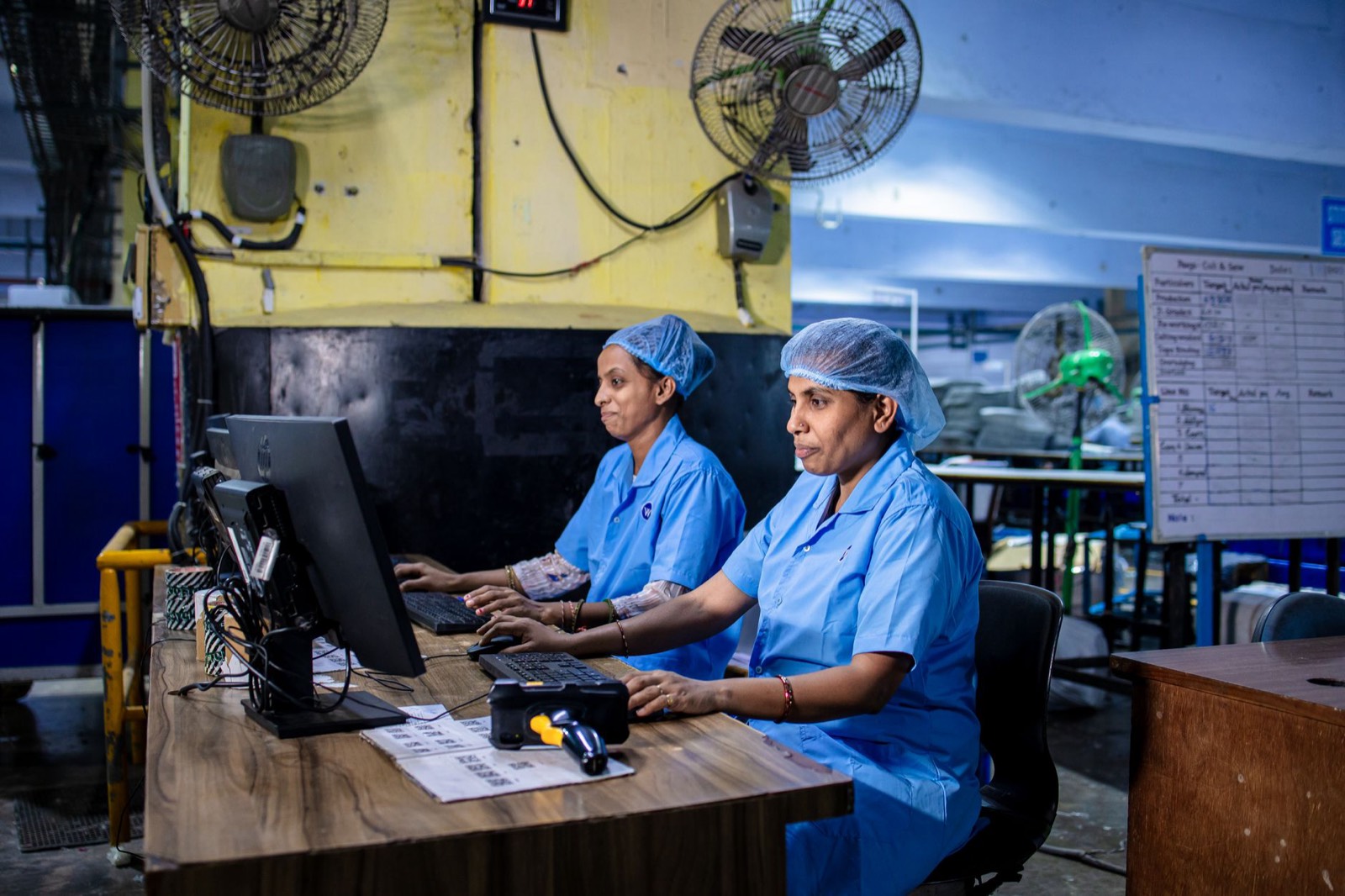 Poste informatique de prépresse relié à une imprimante textile dans un atelier de marquage
